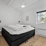 Schlafzimmer mit Bett, Fenster und Holzboden