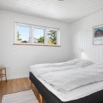 Schlafzimmer mit Doppelbett, Fenster und Wandbild.
