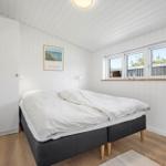 Schlafzimmer mit Doppelbett, weißen Wänden und Fensterblick.