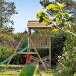 Holzspielplatz mit Rutsche und Schaukel im Garten