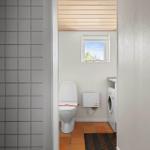 Badezimmer mit Toilette, Waschmaschine und Fenster