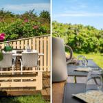 Terrasse mit Tisch und Stühlen, umgeben von grünen Pflanzen und rosa Blüten.