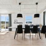 Dining room with table, chairs, and large windows offering outdoor views.