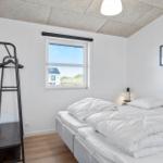 Bedroom with double bed, clothing rack, and window overlooking green areas.