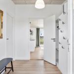 Hallway with mirror, bench, and closet. Corridor to kitchen and terrace.
