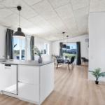 Kitchen with dining area, wooden floor, and large windows.