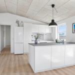 Kitchen with white cabinetry, dark countertop, and window with view outside.