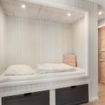 Ein Bett in einer Nische mit weißen Wänden und einem Holzschlafzimmer