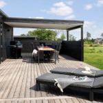 Terrasse mit Liegestühlen, Grill und Tisch unter Dach