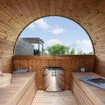 Holzsauna mit Sitzbänken und runder Aussichtöffnung nach draußen.