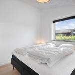 Schlafzimmer mit Bett, Fenster und Holzboden