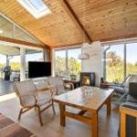 Living room with wooden ceiling, seating, and view of the garden.
