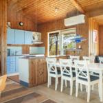 Kitchen and dining area with wooden walls, blue cabinets, and white table with chairs.