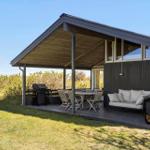Deck with grill, table, and bench under roof