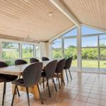 Esszimmer mit Holztisch, Stühlen und großem Fensterblick auf Garten