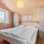 Schlafzimmer mit Holzwand, Bett und Fenster. Decke mit Lampen.