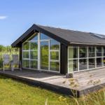 Moderne Hütte mit großem Holzdeck und Glastüren zur Außenterrasse.