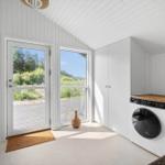 Wohnraum mit Tür und Fenster, Blick auf Grünland, Waschmaschine und Schrank.