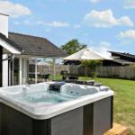 High-quality hot tub in the garden with seating and umbrella.