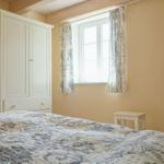 Schlafzimmer mit Bett, Kleiderschrank, Fenster und Fernseher auf Tisch