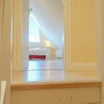 Durchgang zu einem Schlafzimmer mit Bett und Fenster