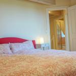 Schlafzimmer mit Bett, Nachttisch und Tür zum Bad