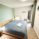 Schlafzimmer mit Holzbett, blauer Bettwäsche und Holzboden.