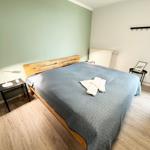 Schlafzimmer mit Bett, Nachttisch und Holzboden.