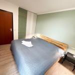 Schlafzimmer mit Bett, Holzfußboden und grüner Wand