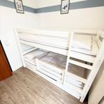 Zimmer mit weißem Doppelstockbett und Holzboden