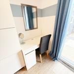 Schreibtisch mit Stuhl, Spiegel und Vorhang an Fenster