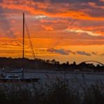 Segelboot vor Sonnenuntergang mit Brücke im Hintergrund