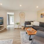 Wohnzimmer mit Sofa, Fernseher und Holztisch