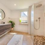 Badezimmer mit Dusche, Waschbecken und Fenster