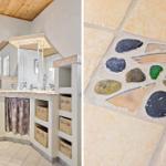 Badezimmer mit Waschmaschine und Mosaikboden aus Steinen und Glas.