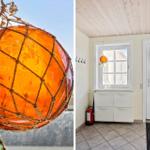 Ein orange-gelber Buoyschmuck hängt im Fenster. Ein Eingangsbereich mit weißer Tür und Schrank.