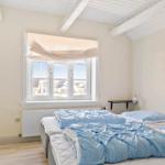 Schlafzimmer mit Bett, Fenster und Holzbalken an der Decke.