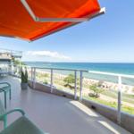 Terrasse mit orangefarbenem Markisenüberdachung und Meerblick.