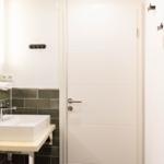 Badezimmer mit Waschbecken, Spiegel und Handtuchhalter.