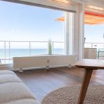 Wohnzimmer mit Blick aufs Meer und Balkon mit Liege