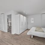 Schlafzimmer mit Bett, Kleiderschrank und Blick auf Terrasse