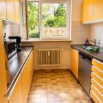 Küche mit gelben Schränken, Fenster und Waschbecken