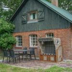 Haus mit Holz- und Ziegelbauweise, Terrasse mit Tisch, Stühlen und Liegestuhl.