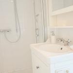 Badezimmer mit Dusche, Waschbecken und Spiegelschrank.