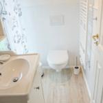 Badezimmer mit Waschbecken, Toilette und Duschvorhang.