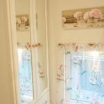 Schrank mit Spiegeltüren und Fenster mit floralen Vorhängen