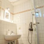Badezimmer mit Dusche, Waschbecken und Fenster.