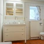 Badezimmer mit Waschmaschine, Toilette und Spiegelschrank.