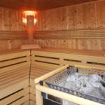 Holzsauna mit Sitzbänken und Steinmulde