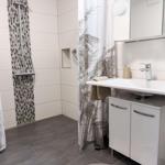 Bathroom with shower, sink, and mirror cabinet.